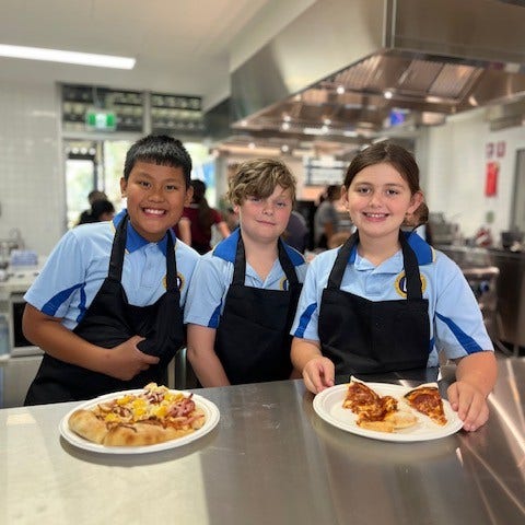 Students cooking and showing off their food