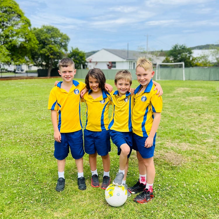 Four boys on the field with soccer ball