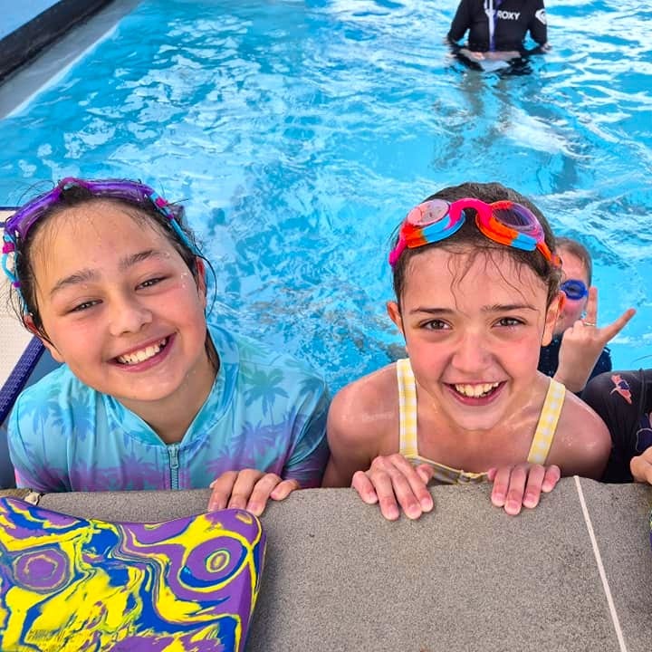 2 girls smiling at swimming pool
