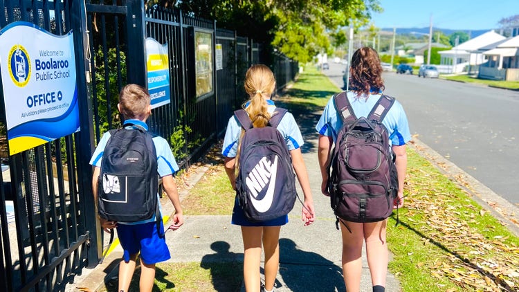 3 students walking to school with their backpacks on