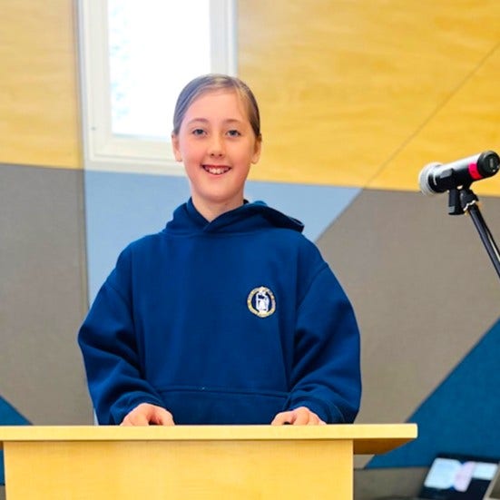 A girl public speaking on stage